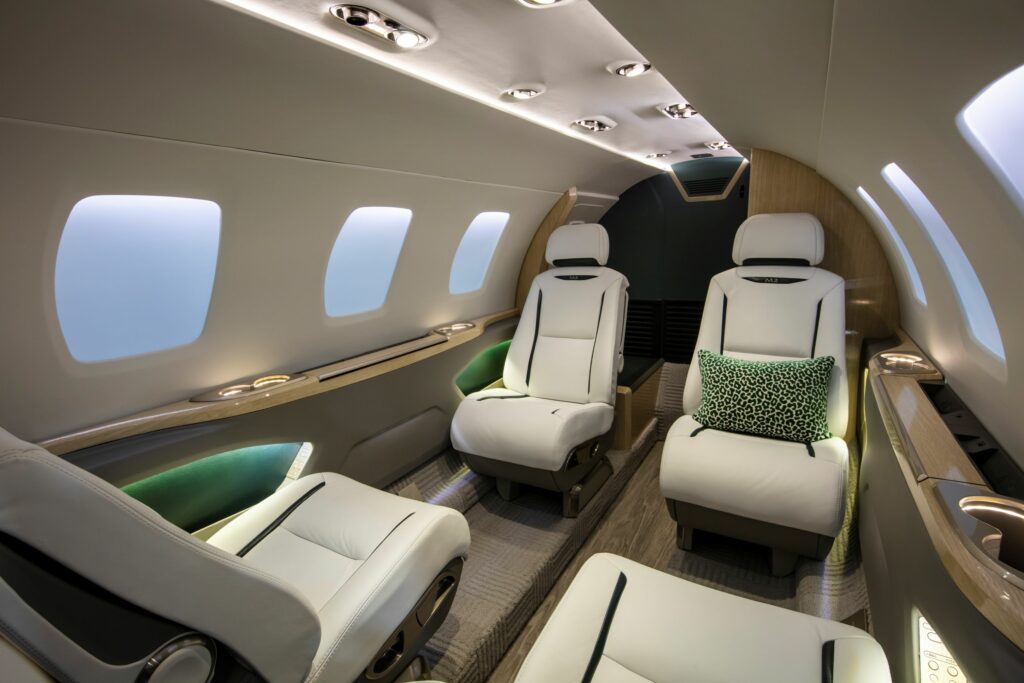 Intérieur luxueux d'un Cessna Citation M2 avec des sièges en cuir blanc et des accents verts – Design intérieur frais et moderne pour les vols d'affaires via FA Aircraft Sales.